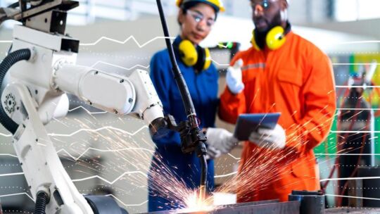 two people using robotic factory equipment