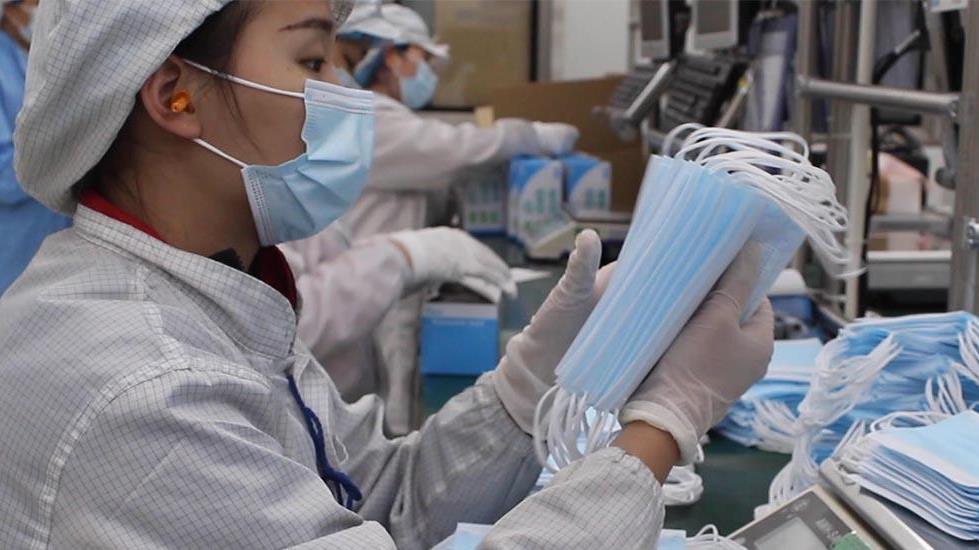 people in factory making masks